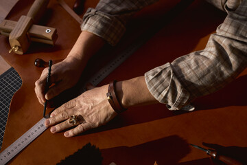 old shoemaker using measuring tape while working in the studio. lifestyle, hobby, occupation,...
