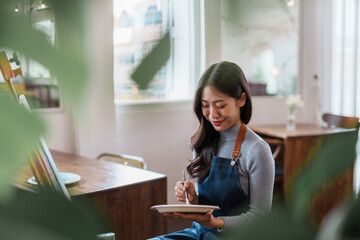 Asian female artist painter on canvas in creative studio as art. Cheerful young asian woman artist smiling drawing at art studio.