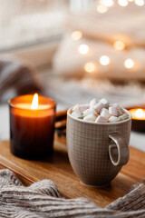 warm cozy window arrangement, winter or autumn concept, coffe, candles throw lights