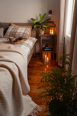 cozy scandinavian bedroom interior in natural tones, blanket candles houseplants