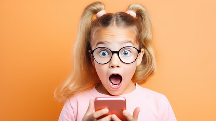 Cute little girl surprised face looking at gadget wearing glasses