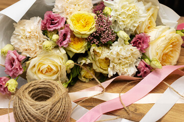 Floristry. Flowers. Multicolored bouquet of roses, carnation, tulip, soft focus. Tools and accessories for making.