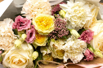 Floristry. Flowers. Multicolored bouquet of roses, carnation, tulip, soft focus. Tools and accessories for making.