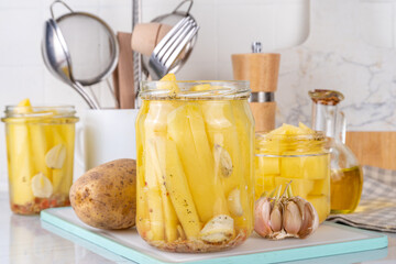 Mexican pickled potatoes, Fermented potato, salted conserved preserved vegetables canned in glass jars on kitchen table