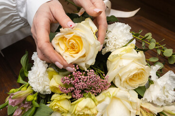 Floristry. Flowers. A florist girl collects a bouquet on the desktop, brown in color.