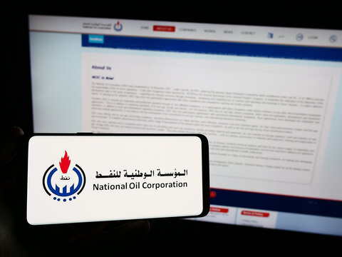 Stuttgart, Germany - 12-07-2023: Person holding smartphone with logo of Libyan petroleum company National Oil Corporation (NOC) in front of website. Focus on phone display.