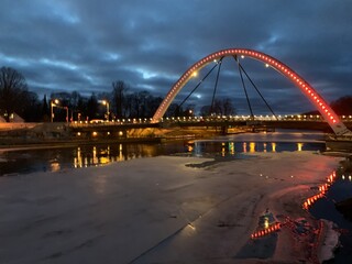 Obraz premium Vabadussild bridge over frozen Emajõgi river at night in Tartu, Tartumaa, Estonia, February 2021