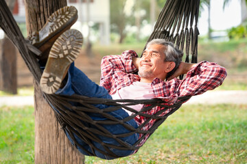 happy mature man laying on a hammock at resort garden on summertime,concept of people lifestyle,holidays,travel,camping,adventure