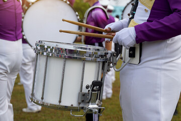 Marching band drummer plays music during the school sports day parade. Soft and selective focus.  