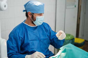 Fototapeta na wymiar Surgeon asking for sterile material in his operating room while performing the intervention