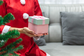 Asian women with Christmas suit with gift box on hand for giving season on new year