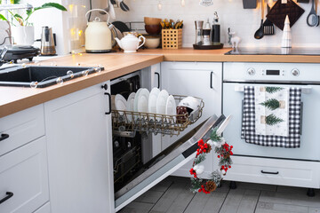 A lot of dirty dishes in the dishwasher in the festive kitchen. Helping the hostess, economy and...