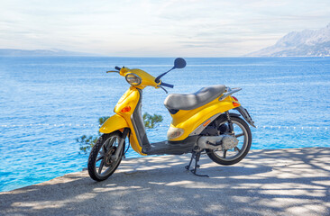 Obraz premium Yellow brand-less moped on the beach on a summer day. Croatia
