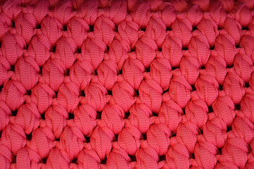 Braided background made of crimson, pink, dense thread. Beautiful structures, braided, unique pattern.