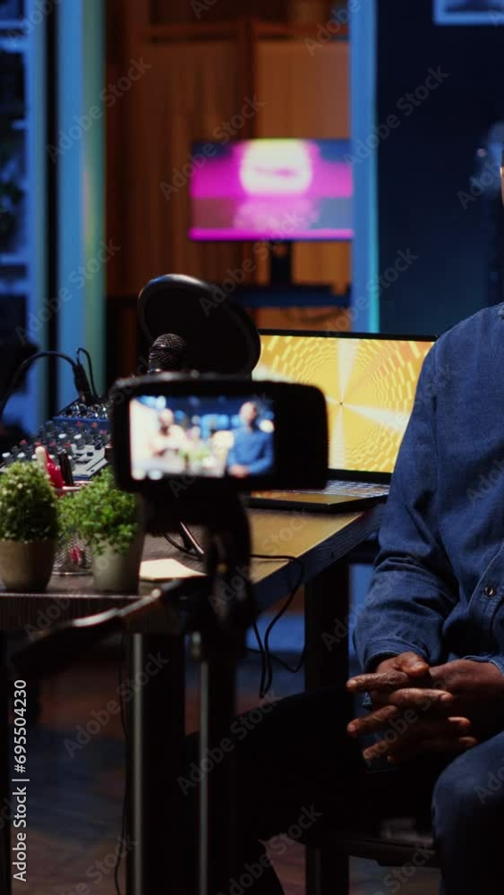 Poster vertical video content creator recording interview with professional camera in studio, reviewing not
