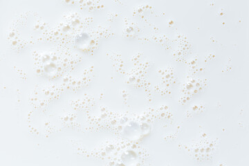Macro milk close-up texture,Over head close up full frame background detail view of frothy white milk creating bubbles, indoors. Macro still life view of liquid milk drink