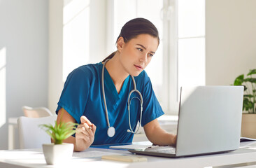 Woman doctor or nurse working with laptop in a hospital office, show the essence of virtual medical...