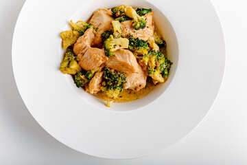 Vindaloo with spinach in white bowl isolated on white background. Portuguese Influenced Indian dish made by cooking chicken in vindaloo spice paste and broccolli.