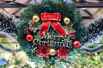 Merry Christmas badge with shiny balls and red ribbon on green decoration