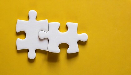 top view two piece of white jigsaw puzzle on a yellow background with copy space