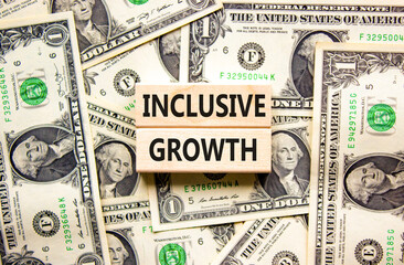 Inclusive growth symbol. Concept words Inclusive growth on beautiful wooden blocks. Dollar bills....