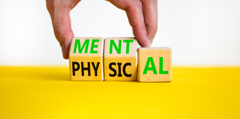 Mental or physical symbol. Concept word Mental or Physical on wooden cubes. Beautiful yellow table...