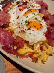 appetizing potatoes with fried eggs and acorn-fed iberian cured ham