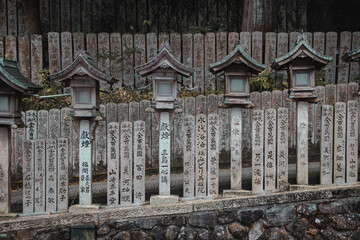 Sinto shrine with japanese text engraved in stone and stone lanterns from ikoma-nara
