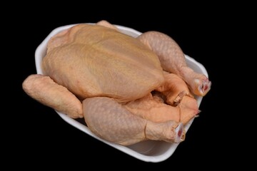raw whole chicken on black background