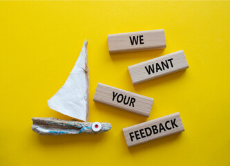 We want your feedback symbol. Wooden blocks with words We want your feedback. Beautiful yellow background with boat. We want your feedback concept. Copy space.