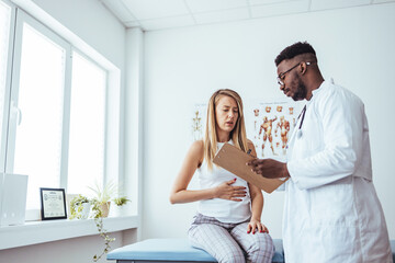 A woman in consultation with a doctor with abdominal pain. It is a painful menstrual period or bladder. And ectopic pregnancy. Immediate treatment immediately - obrazy, fototapety, plakaty