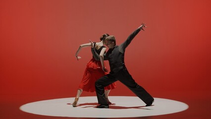 Elegant Ballroom Dance Couple on Spotlight red background.