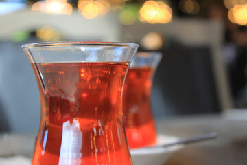 Black Turkish tea in thin glass cup for two, prepared for breakfast in sunny, luxurious restaurant....