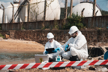 Scientist wear protection suit checking chemical and water analysis and water quality from factory. Protecting Against Hazards and Contamination.