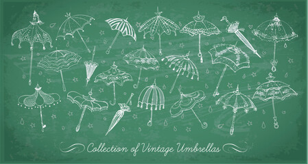 Collection of doodle vintage umbrellas on blackboard background. Vector sketch illustration. © elinacious