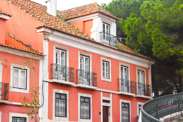 Exterior facade of red historical house with apartments in Lisbon, Portugal. Urban vintage background. Alfama district.