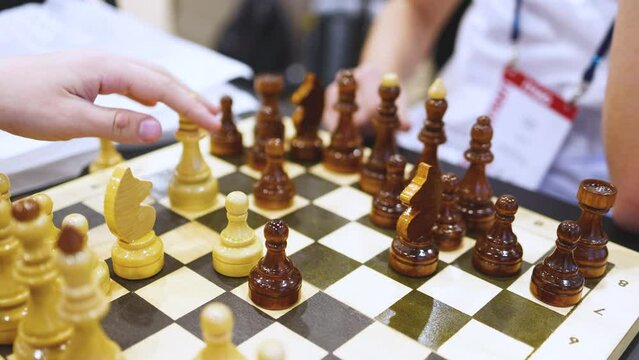 Chess tournament, kids and adults participate in chess match game outdoors in indoor hall, players of all ages play, competition in chess school club with chessboards on a table