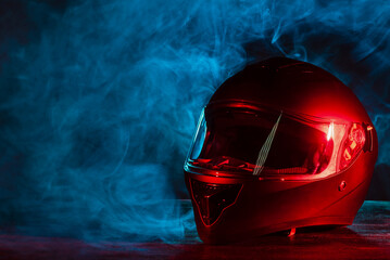 Modern motorcycle helmet on the shop counter in the smoke in the neon lights background with copy...