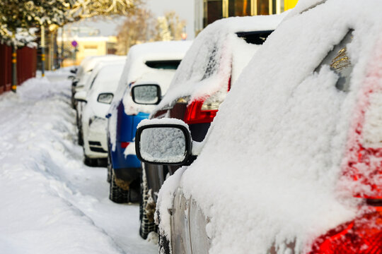 Row of fresh snow layer covered cars parked on the side of snow covered street