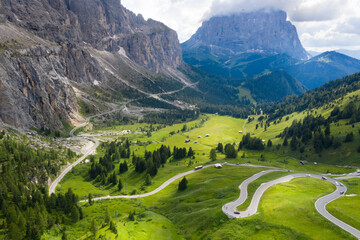 Aerial drone shot of picturesque Dolomite Alps ridges and peaks. Passo Gardena Green hills with...