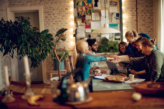 Group of young people sharing pizza during home study session