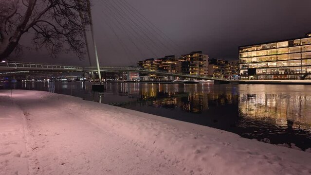 Walking along the river in Drammen city, Norway.The river is called Drammenselva, and the bridge is called Ypsilon.  The city's library is located on the right side of the river.