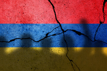 Armenia and Azerbaijan conflict in Nagorno Karabakh. Armenian flag on the cracked concrete wall with protesters