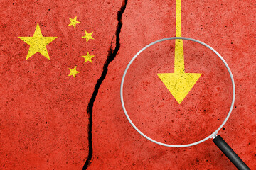 China flag painted on a cracked concrete background. China finance, real estate and debt crisis....