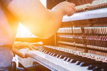 Soft Focus and Blur,The pianist is fixing and adjusting the sound of the piano correctly and precisely so that the practice and performance of the piano will be melodious and without glitches. - obrazy, fototapety, plakaty