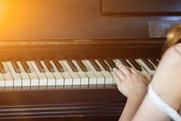 Piano Player's Performance: A child, hands on keys, plays classical music with ease, filling the...