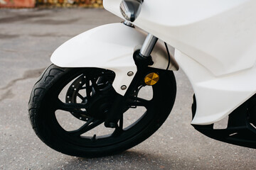 Close up front wheel of motorbike on asphalt road