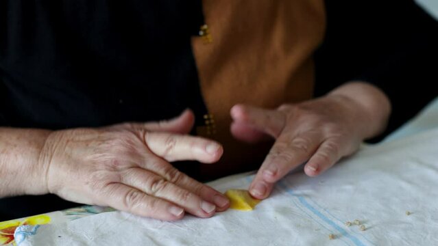 Woman's hands preparing the traditional fresh Italian pasta Cappelletti. Homemade pasta production process. Conceptual of typical Italian Christmas family cooking. Chef at work Romagna Bologna