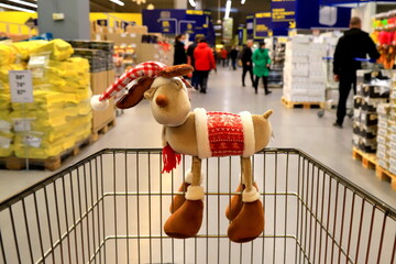 Christmas, New Year sale, shopping. Funny Christmas deer on supermarket trolley. Basket in...