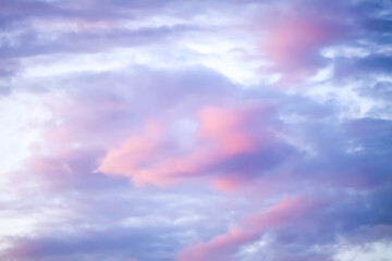 Bright sunset sky with gentle colorful clouds.